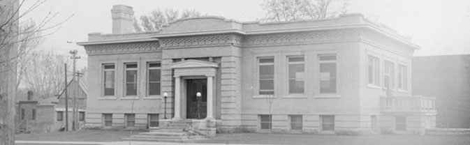 black and white photograph of a building with pillars around front door