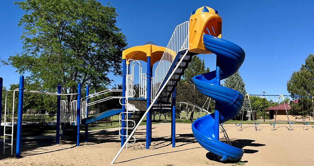 A brightly colored play structure appears against a cloudless sky.