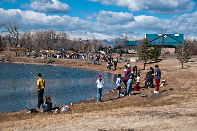 Groups of people gathered on banks of lake fishing