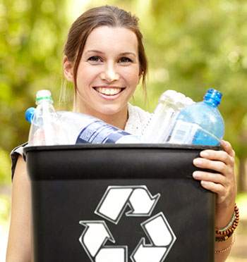 Woman holds black or brown recycling container