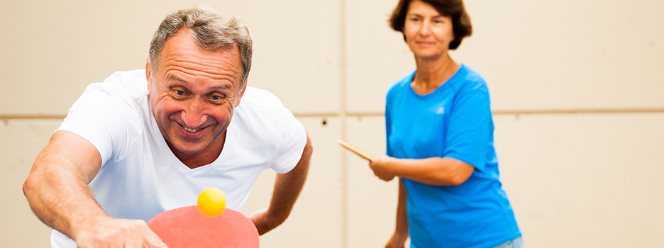 a mature man and women play table tennis