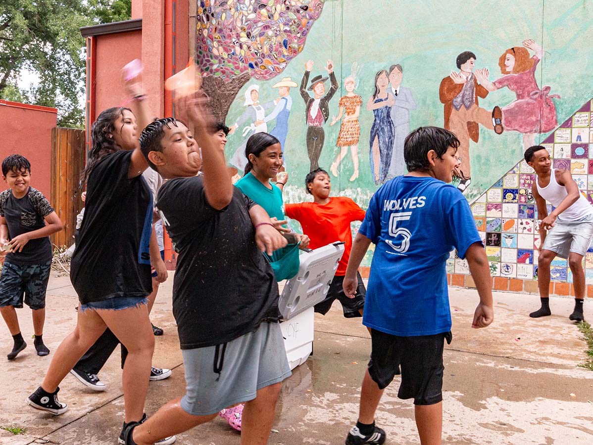 Youth toss water balloons at each other on a hot day outside of the Longmont Youth Center.