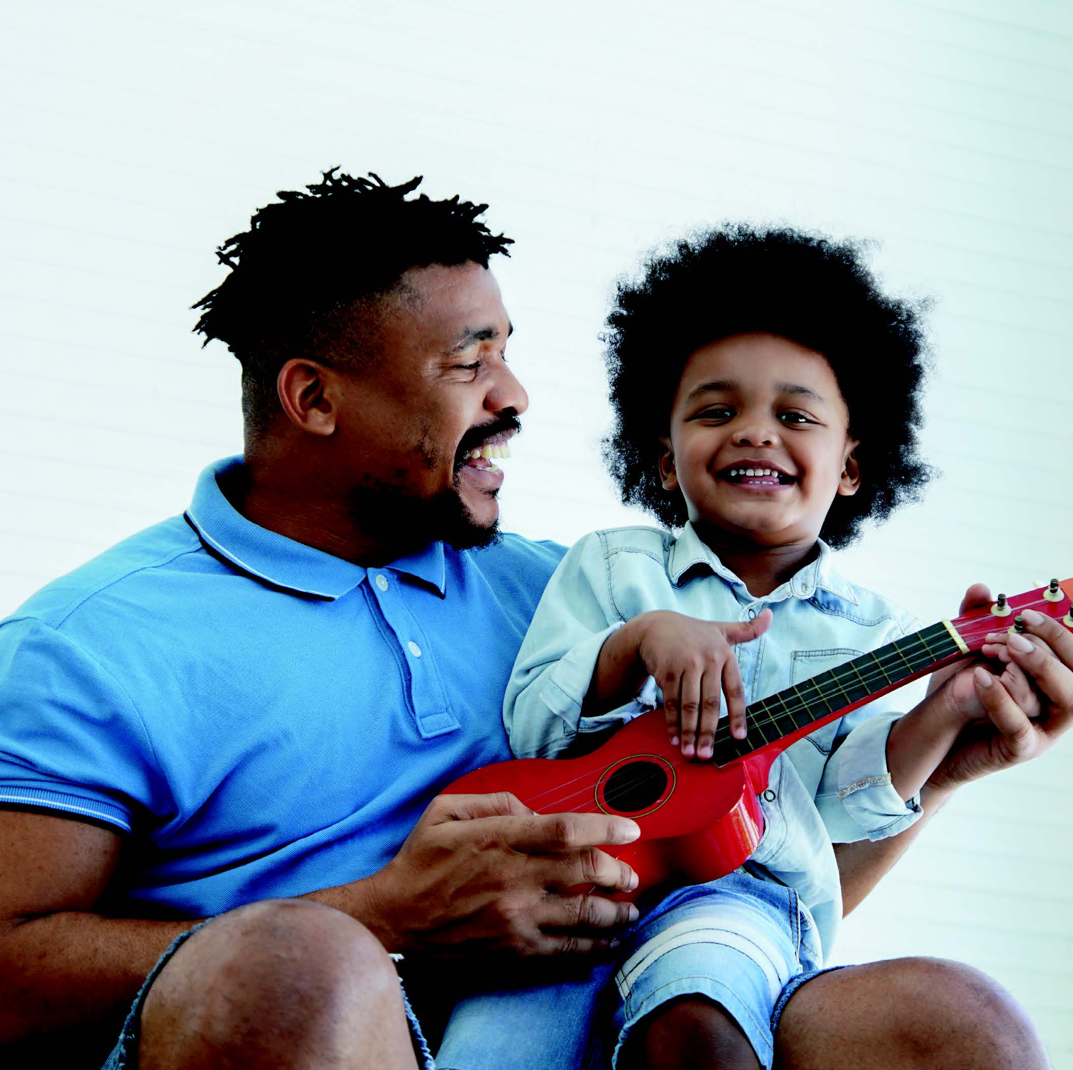 A father and son playing ukulele together