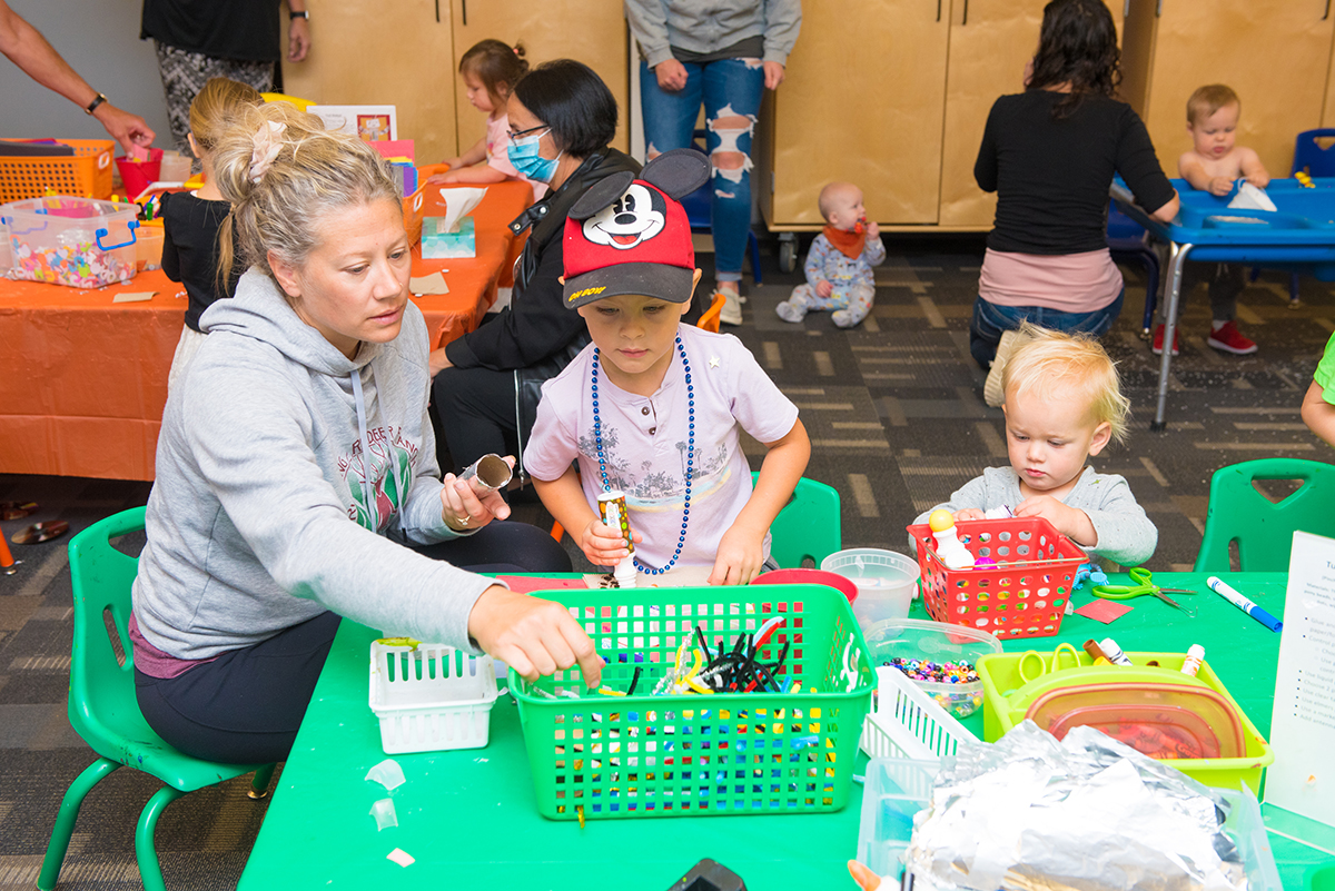 Children making crafts with a caregiver