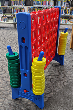 A giant connect 4 lawn game with yellow and green pieces