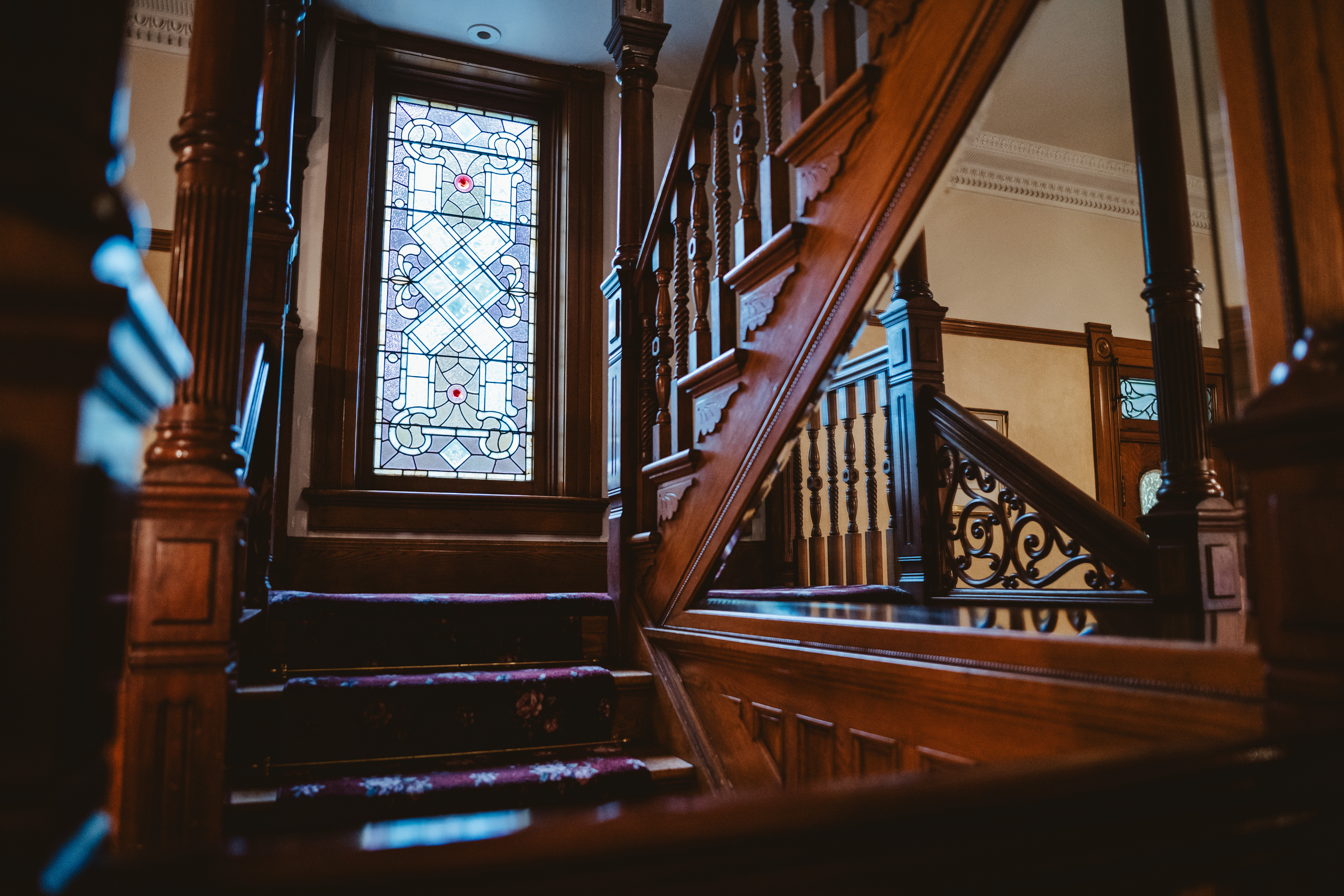 Callahan House main staircase with view of hand crafted stained-glass window