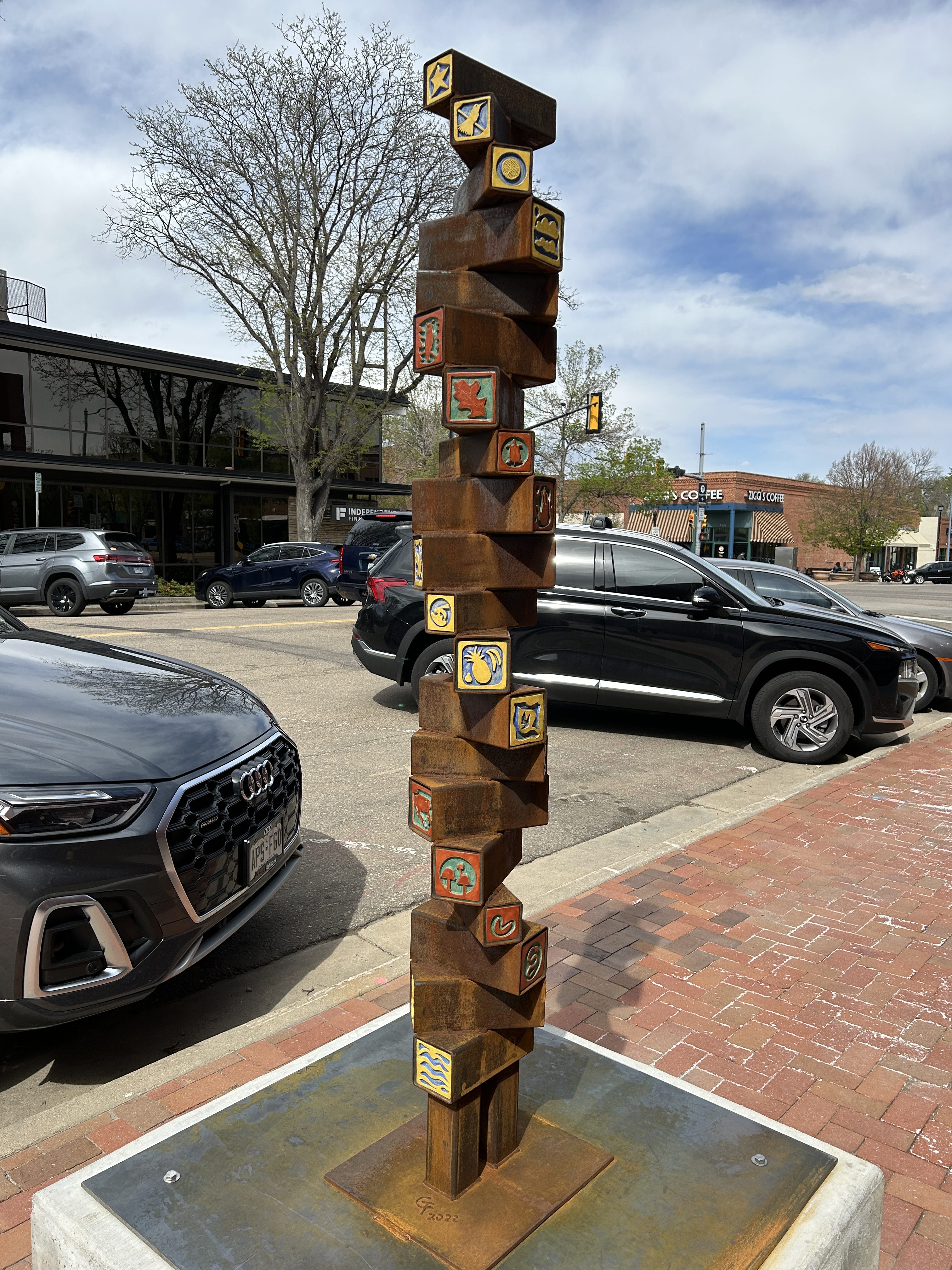 a sculpture in steel with colorful tiles stacked in rectangular tubes