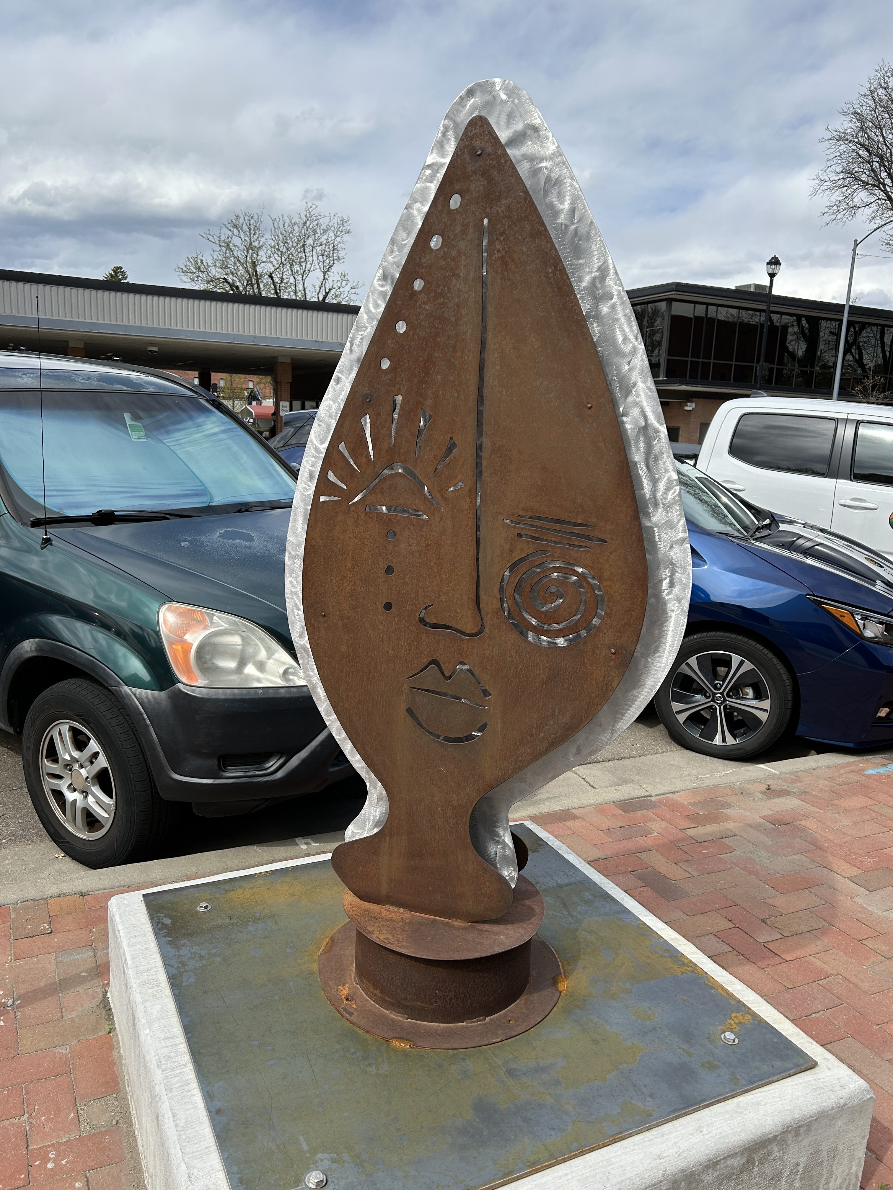 a sculpture of a face in bronze and silver